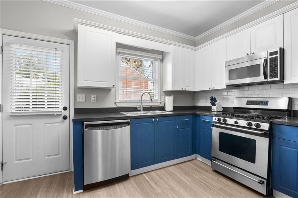 3675 Peachtree Road Northeast, Unit 45 Atlanta, GA 30319 - Photo 11 of 42 a kitchen with granite countertop wooden cabinets stainless steel appliances and a window