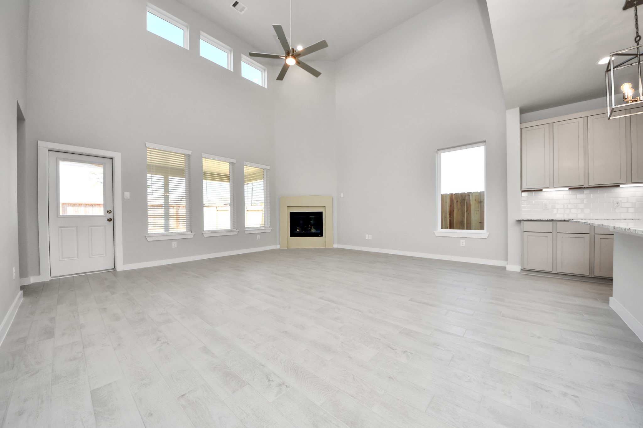 2922 Burris Park Drive Spring, TX 77373 - Photo 19 of 37 Relax and unwind in this inviting family room, illuminated by abundant natural light streaming in through tall windows, complemented by high ceilings and stunning flooring. Stay comfortable year-round with the gentle breeze from the ceiling fan, creating the perfect atmosphere for family gatherings. Sample photo of completed home with similar floor plan. Actual colors and selections may vary.