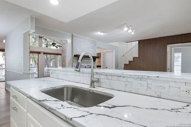 a kitchen with a sink cabinets and a large window