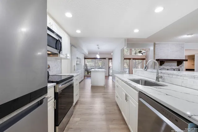 a large kitchen with stainless steel appliances lots of counter space and a sink