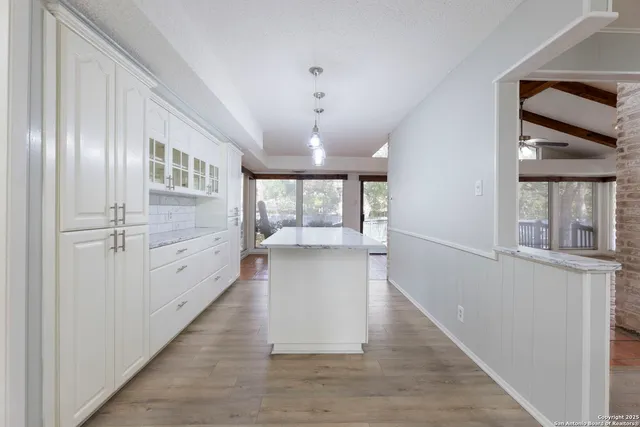 a view of a hallway with wooden floor and cabinet