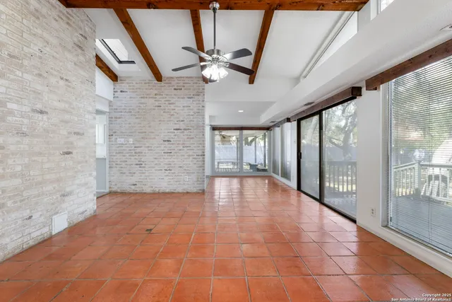 a kitchen with white cabinets and window