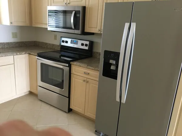 a view of a kitchen with a sink and a refrigerator