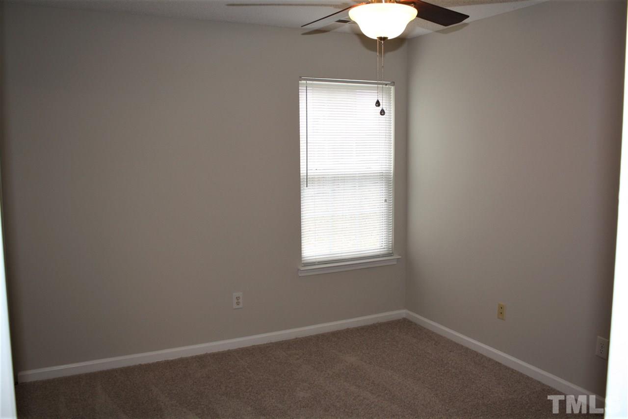 8912 Shallcross Way Raleigh, NC 27617 - Photo 13 of 20 an empty room with a window and a chandelier fan