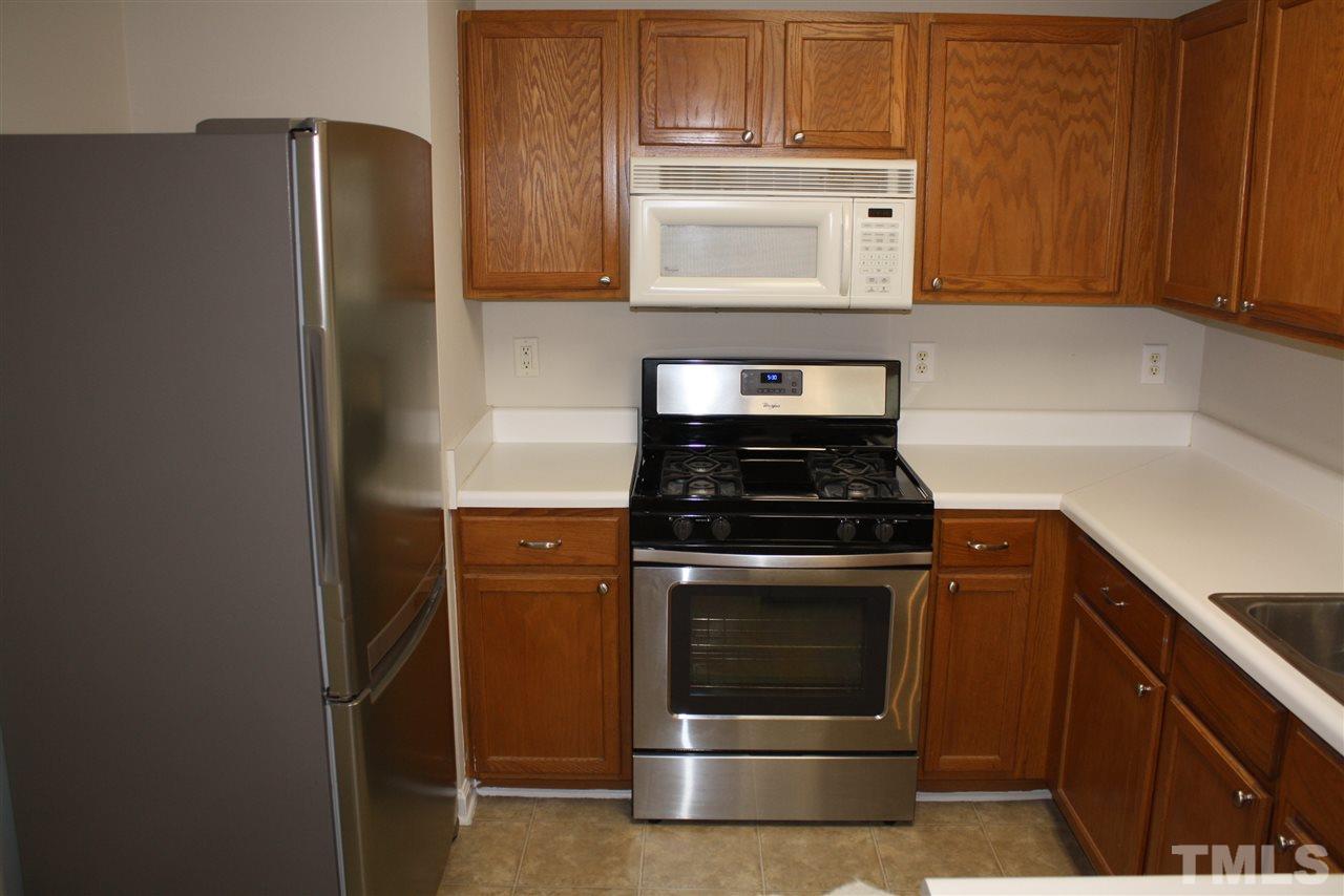 8912 Shallcross Way Raleigh, NC 27617 - Photo 10 of 20 a kitchen with stainless steel appliances wooden cabinets and a stove top oven