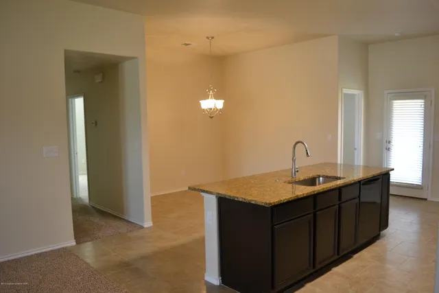 a en suite bathroom with a granite countertop sink and a mirror