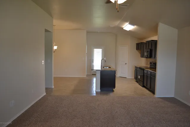 a view of a kitchen with furniture and a refrigerator