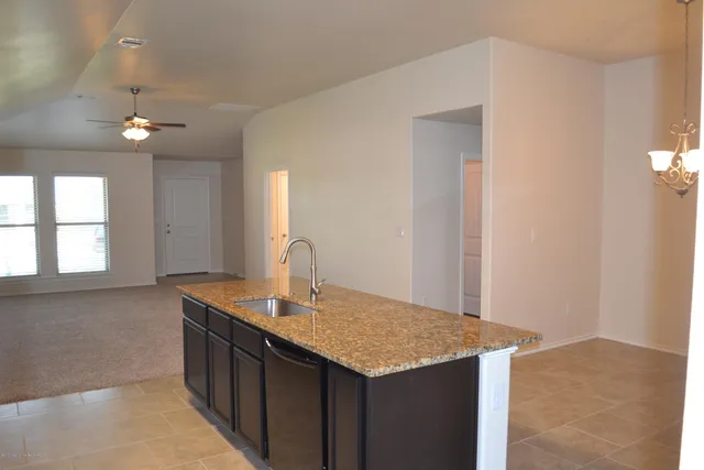 a kitchen with kitchen island a sink refrigerator and window