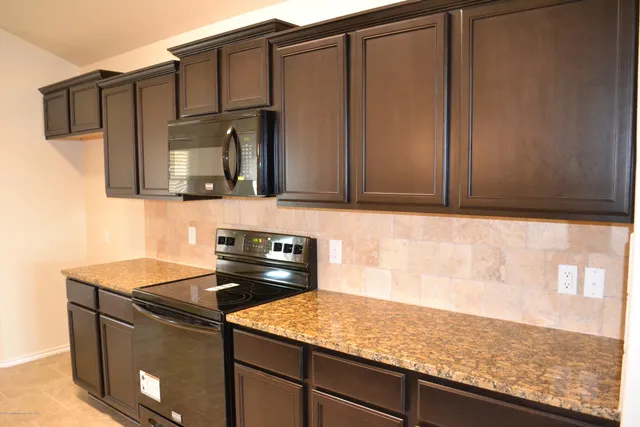a kitchen with granite countertop cabinets sink and stove