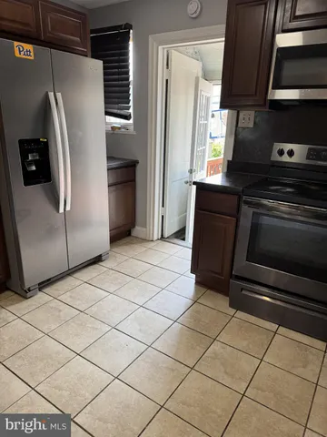 a kitchen with stainless steel appliances granite countertop a refrigerator and a stove