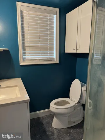 a bathroom with a toilet a sink and a window