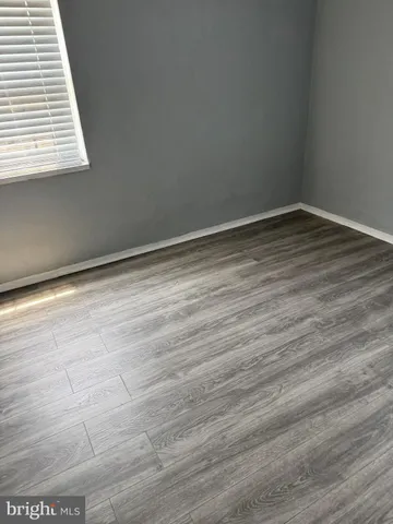 en empty room with wooden floor and a window