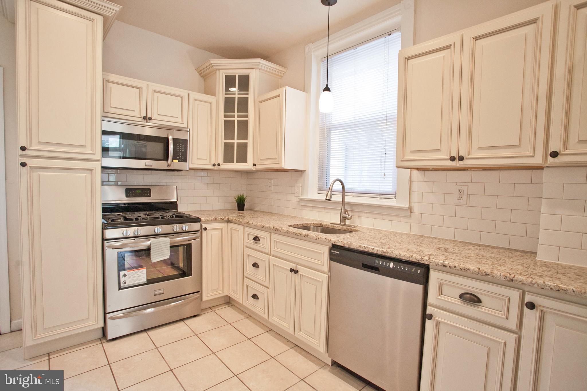 4205 Terrace Street Philadelphia, PA 19128 - Photo 10 of 30 a kitchen with granite countertop white cabinets and white stainless steel appliances