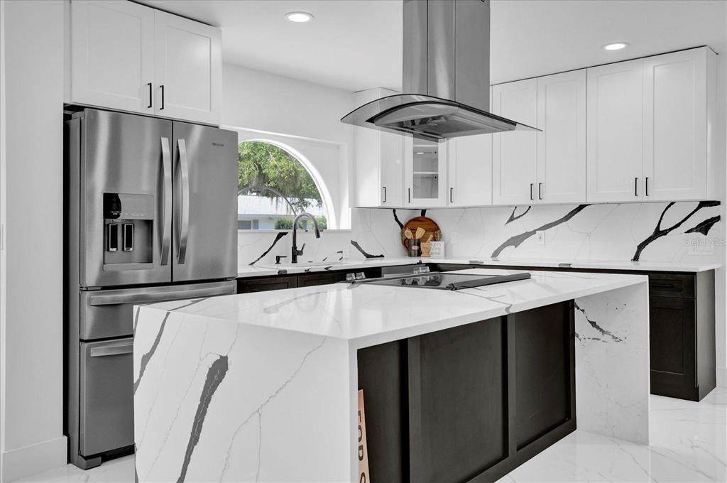 201 Massachusetts Avenue St. Cloud, FL 34769 - Photo 11 of 33 a kitchen with stainless steel appliances a sink a refrigerator a table and chairs