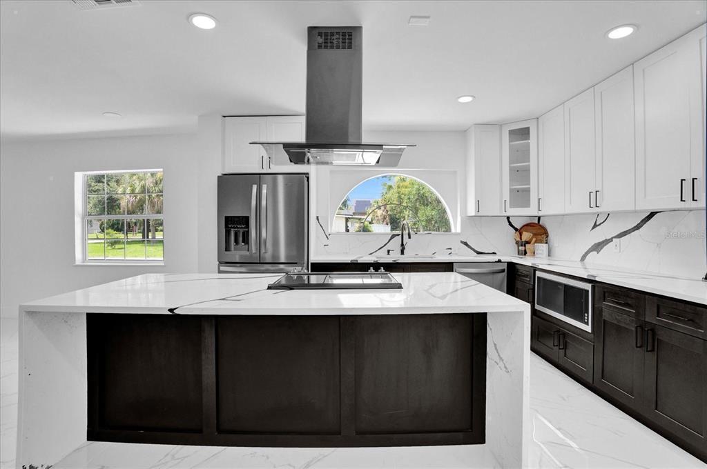 201 Massachusetts Avenue St. Cloud, FL 34769 - Photo 15 of 33 a kitchen with kitchen island granite countertop a sink cabinets and wooden floor