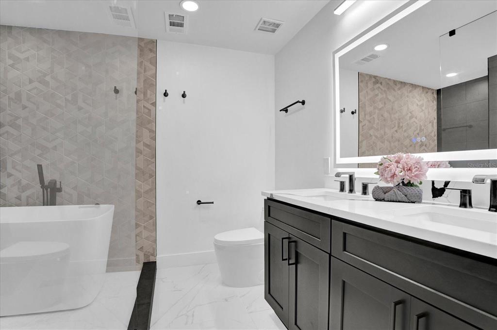 201 Massachusetts Avenue St. Cloud, FL 34769 - Photo 24 of 33 a bathroom with a granite countertop sink a toilet and a mirror