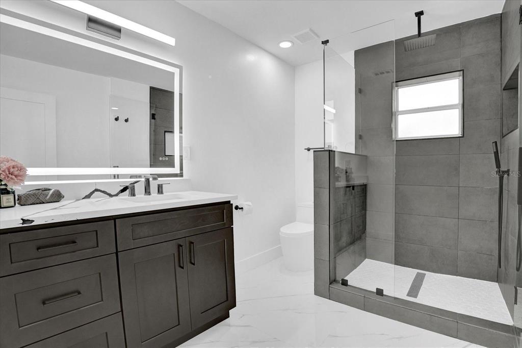 201 Massachusetts Avenue St. Cloud, FL 34769 - Photo 25 of 33 a bathroom with a double vanity sink mirror and shower