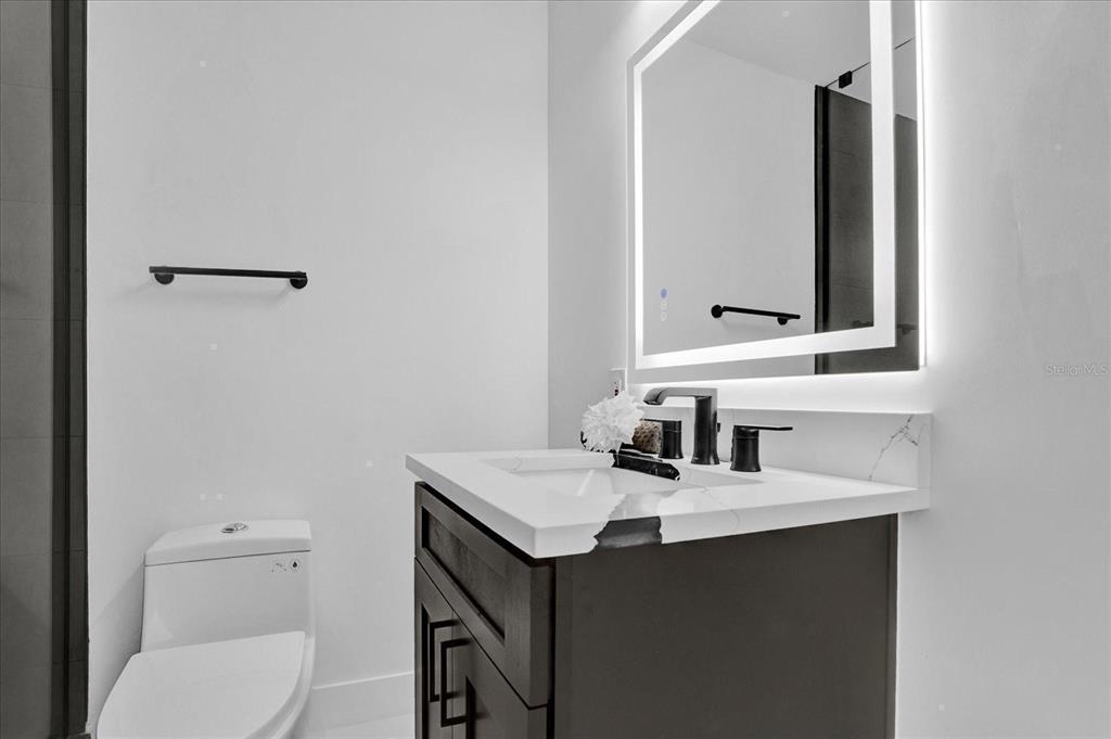 201 Massachusetts Avenue St. Cloud, FL 34769 - Photo 29 of 33 a bathroom with a toilet sink vanity and mirror