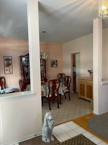 a living room with furniture and a dining table with wooden floor