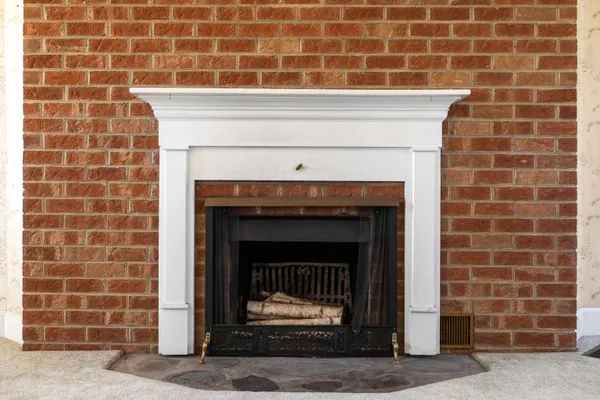 a view of an empty room with a fireplace and a window