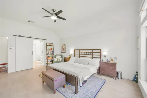 a bedroom with a bed and a flat tv screen on wall