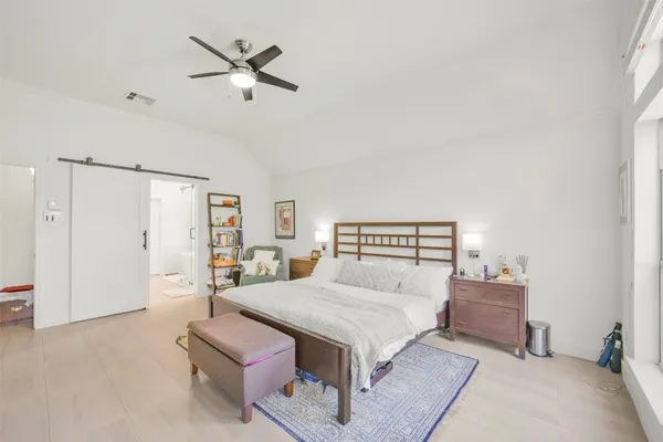 a bedroom with a bed and a flat tv screen on wall
