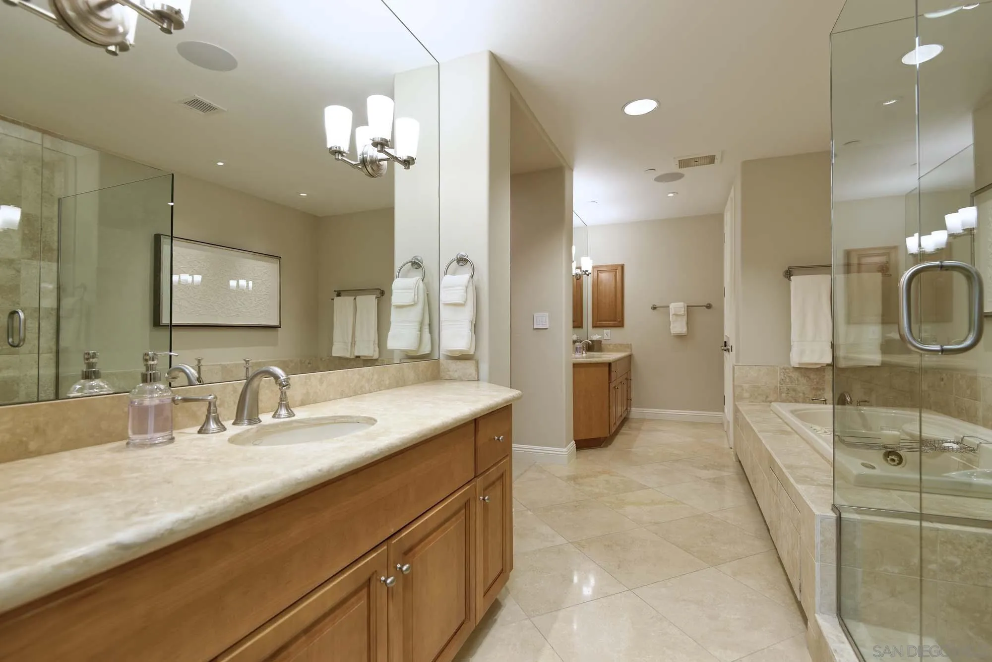 464 Prospect Street, Unit 101 La Jolla, CA 92037 - Photo 15 of 43 a bathroom with a granite countertop sink a large mirror and a shower