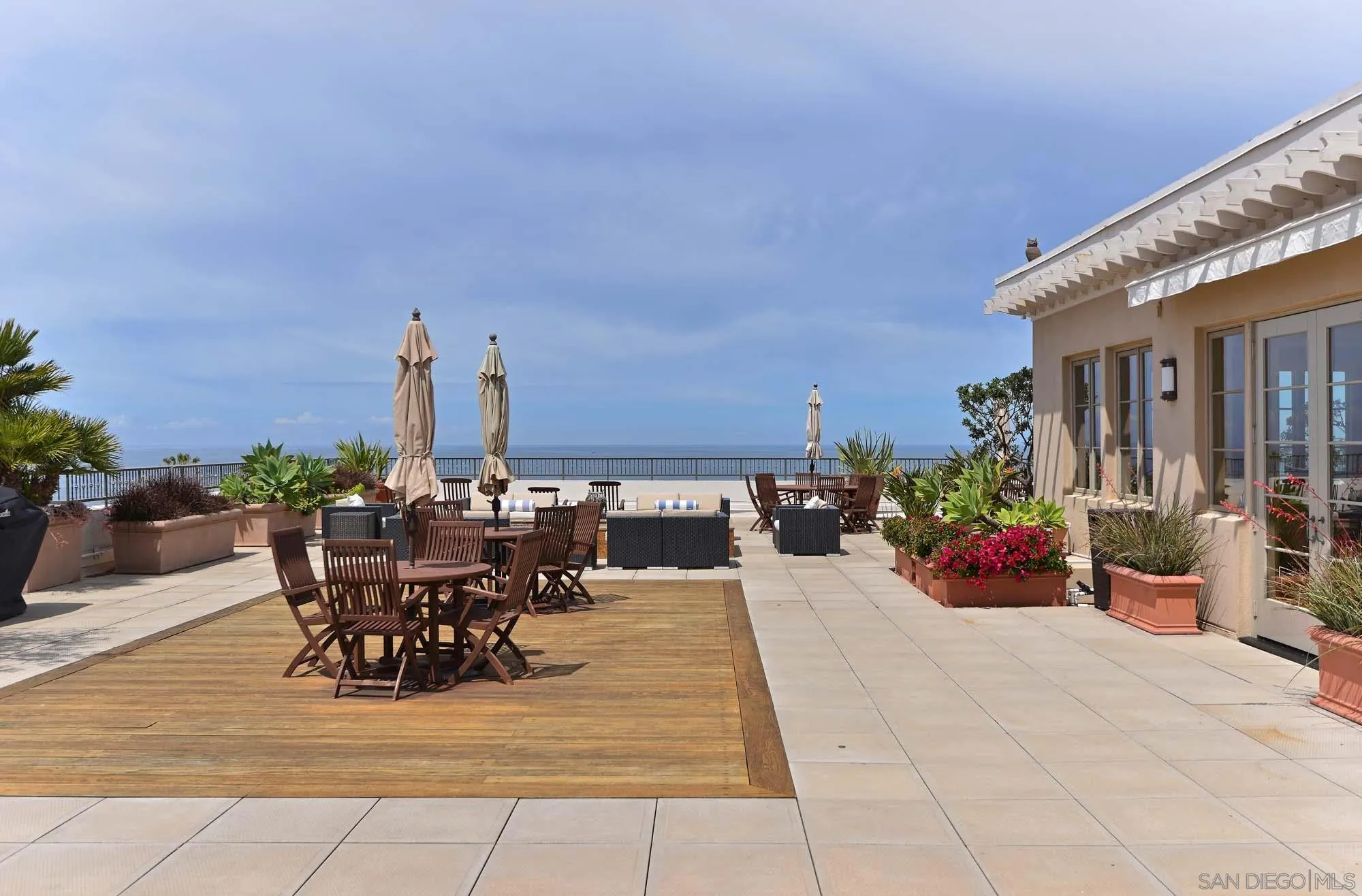 464 Prospect Street, Unit 101 La Jolla, CA 92037 - Photo 41 of 43 a view of a patio with a dining table and chairs and potted plants