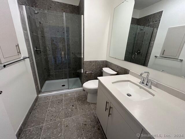 42 John Street, Unit 506 Stamford, CT 06902 - Photo 16 of 23 a bathroom with a sink a toilet a mirror and shower
