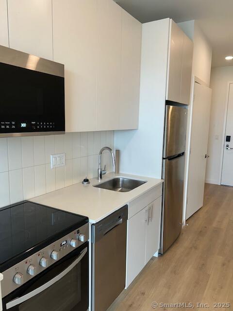 42 John Street, Unit 506 Stamford, CT 06902 - Photo 19 of 23 a kitchen with a sink and a stove top oven