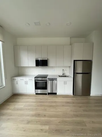 a kitchen with stainless steel appliances granite countertop a refrigerator sink and stove