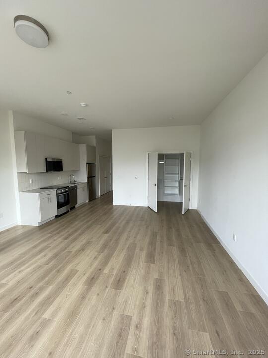 42 John Street, Unit 506 Stamford, CT 06902 - Photo 23 of 23 an empty room with a kitchen and a sink