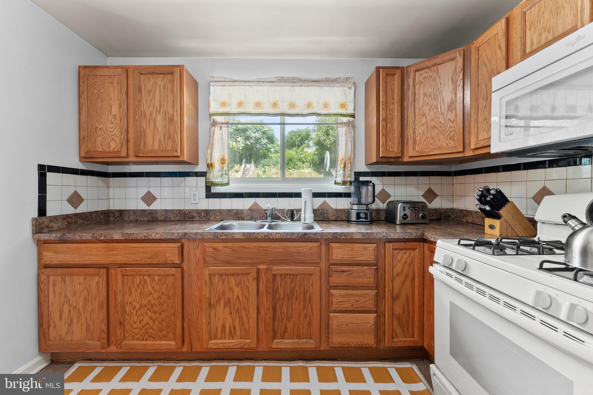 8426 Avery Road Baltimore, MD 21237 - Photo 11 of 25 a kitchen with stainless steel appliances granite countertop a stove a sink and a microwave