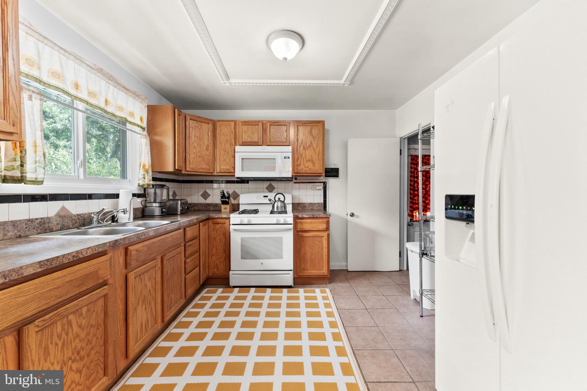 8426 Avery Road Baltimore, MD 21237 - Photo 10 of 25 a kitchen with a stove a sink and a window