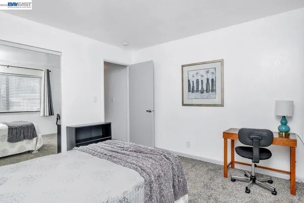 a bedroom with a bed and a chair in it