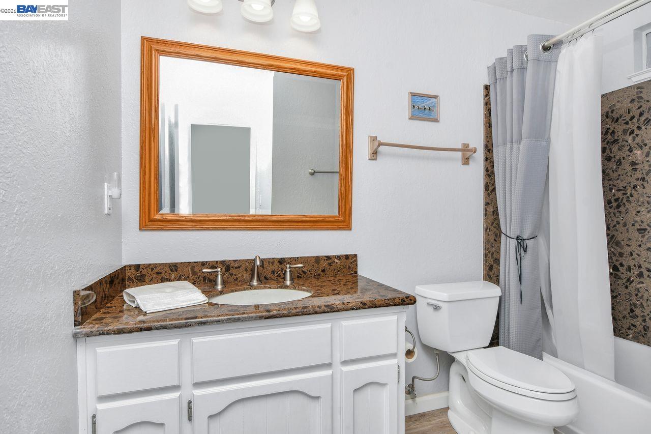 2033 Sand Point Road Discovery Bay, CA 94505 - Photo 16 of 27 a bathroom with a granite countertop sink toilet and shower