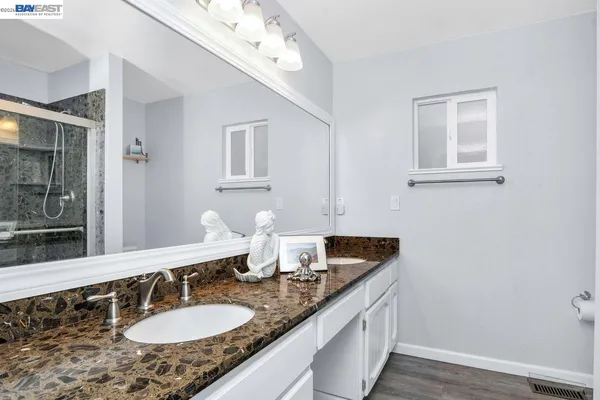 a bathroom with a granite countertop sink a large mirror and vanity