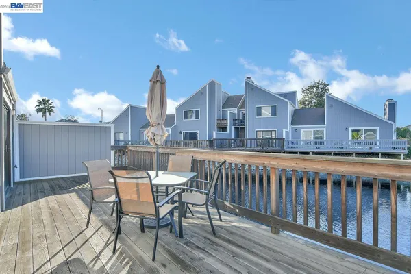 a view of a house with a wooden deck and furniture
