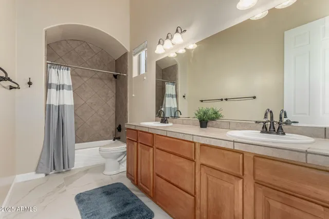 a bathroom with a granite countertop sink a mirror and a shower