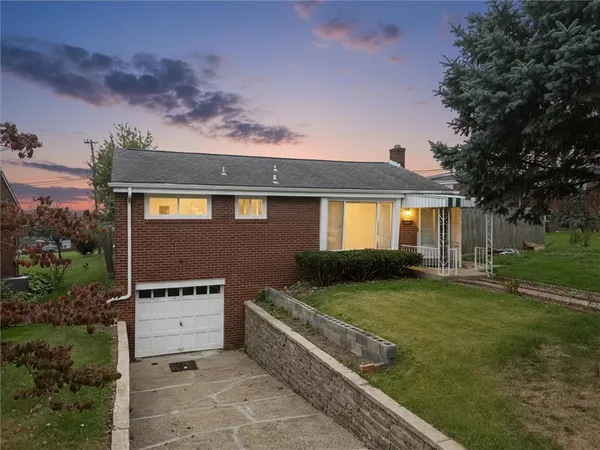 a front view of a house with a garden and yard