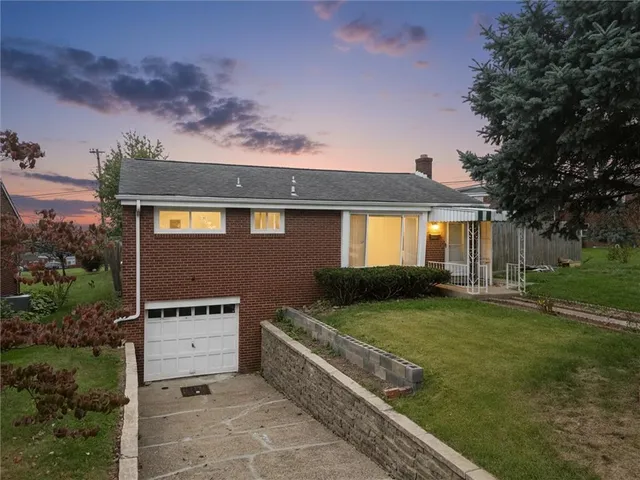 a front view of a house with a garden and yard
