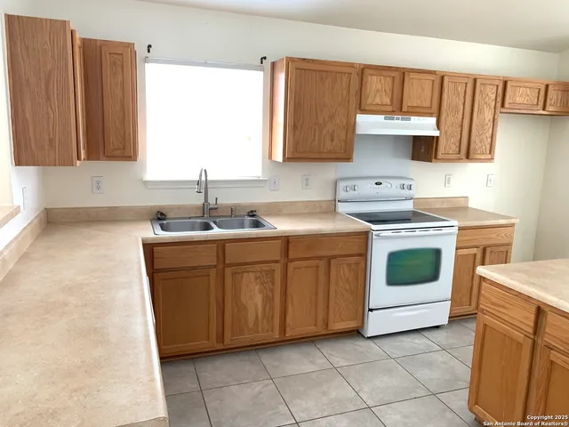 a kitchen with a sink stove and cabinets