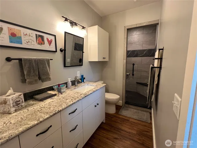 a bathroom with a granite countertop sink and a mirror