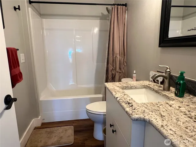 a bathroom with a granite countertop sink toilet and shower
