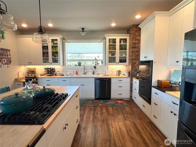 a large kitchen with stainless steel appliances granite countertop a stove and a sink