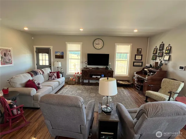 a living room with furniture flat screen tv and wooden floor