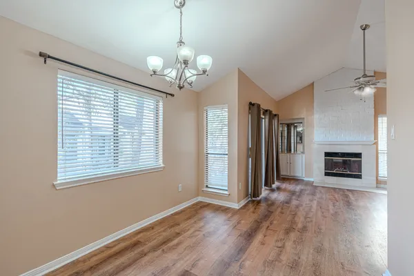 a view of a livingroom with wooden floor and a fireplace