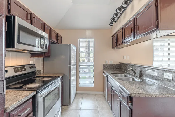 a kitchen with stainless steel appliances granite countertop a sink stove oven and refrigerator