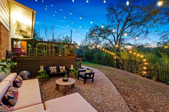 a view of a patio with couches and table and chairs with wooden fence