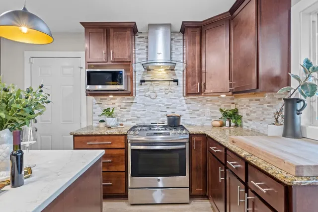 a kitchen with stainless steel appliances granite countertop a sink a stove and a microwave